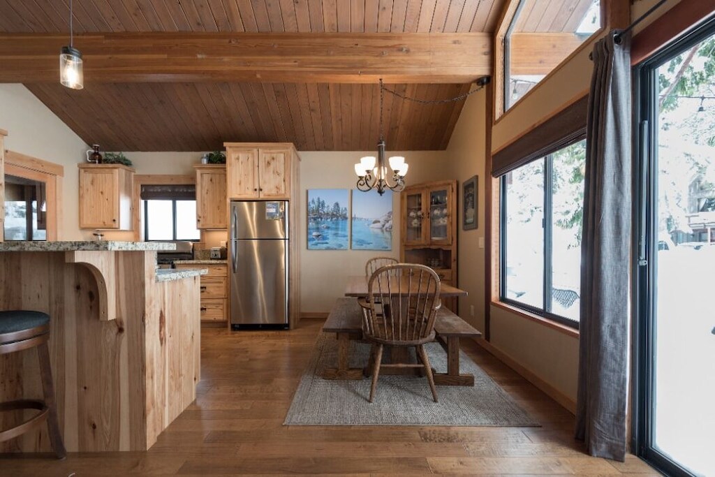 Dining area next to the kitchen with large windows and wooded views.