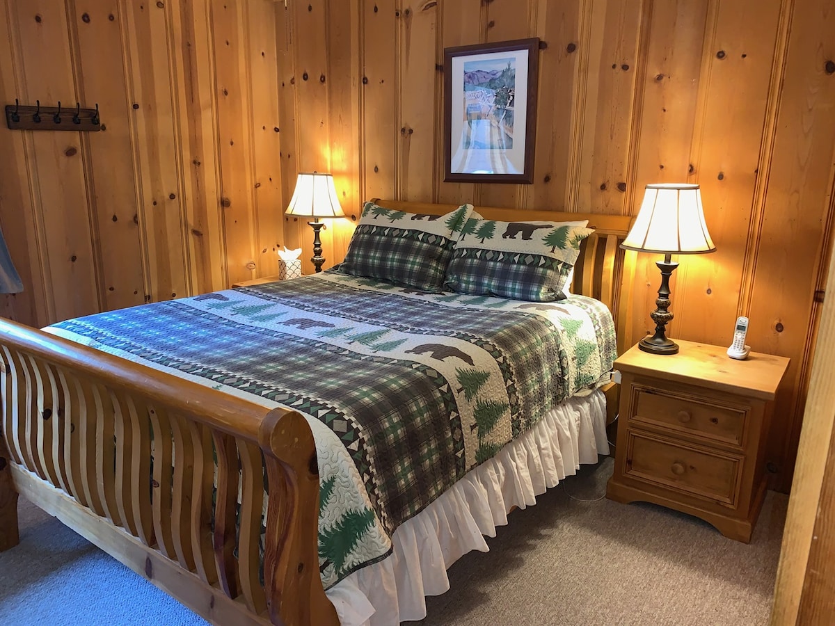 Back bedroom with queen bed and classic wood furnishings.