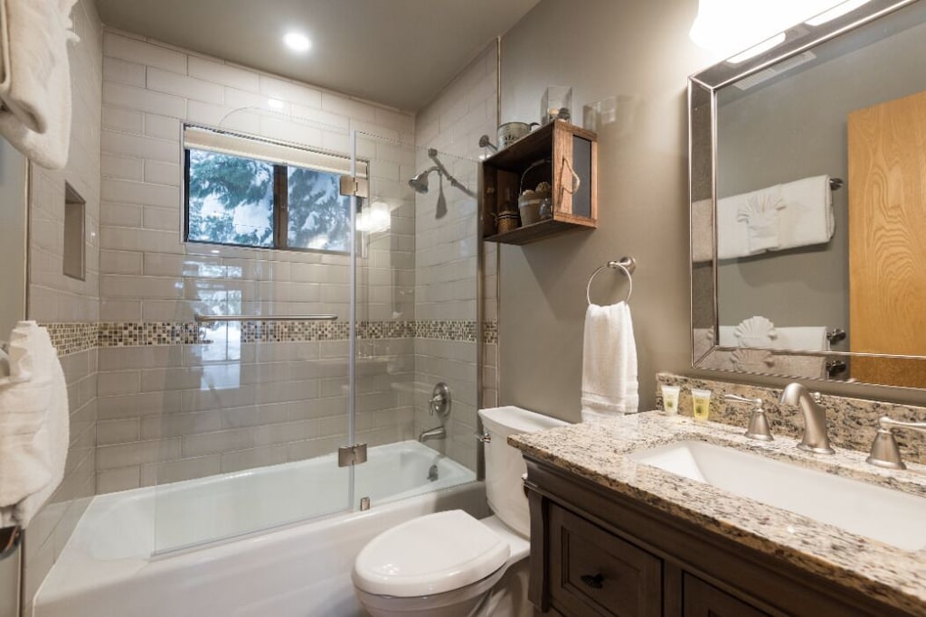 Back bathroom with tub/shower combination and vanity.