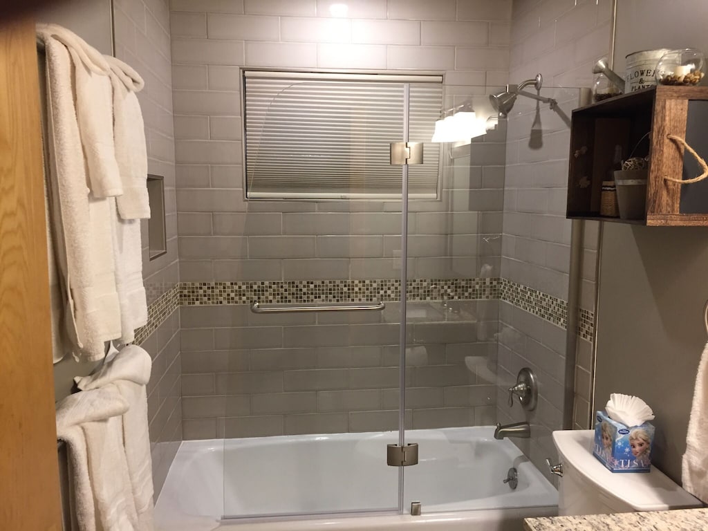 Back bathroom tub/shower with updated tile surround.
