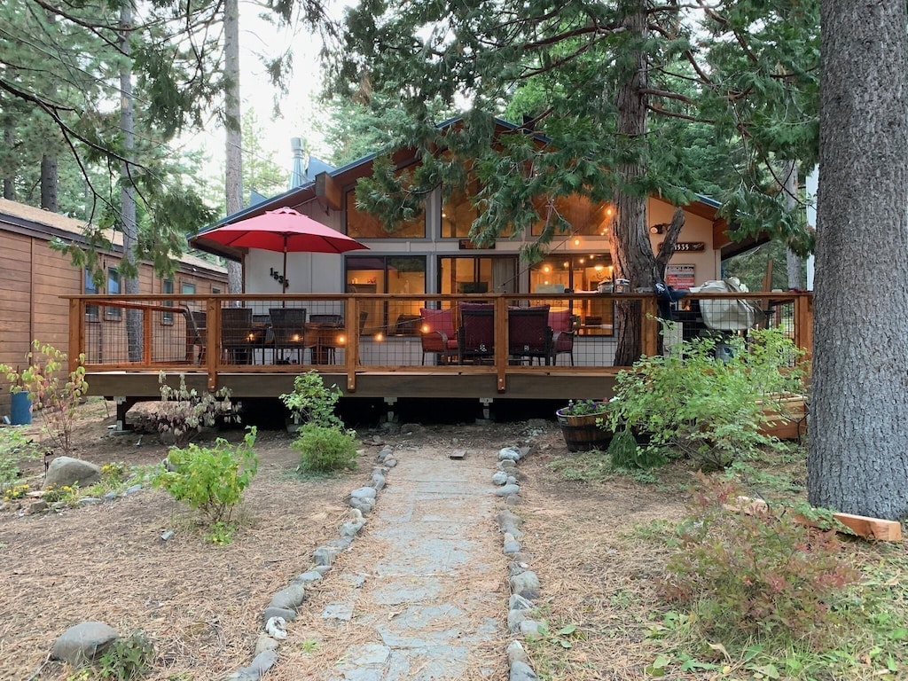 Exterior view of the deck and front approach through the trees.