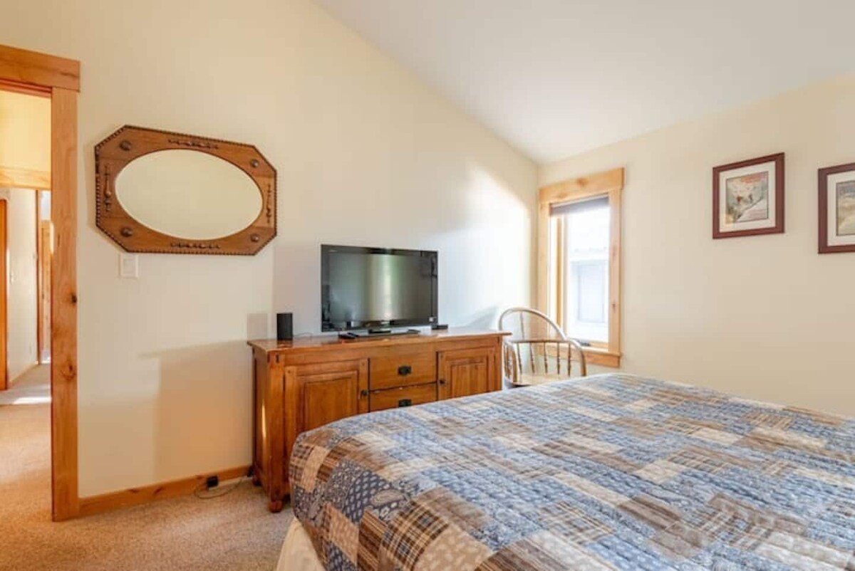 Front bedroom with queen bed and TV.