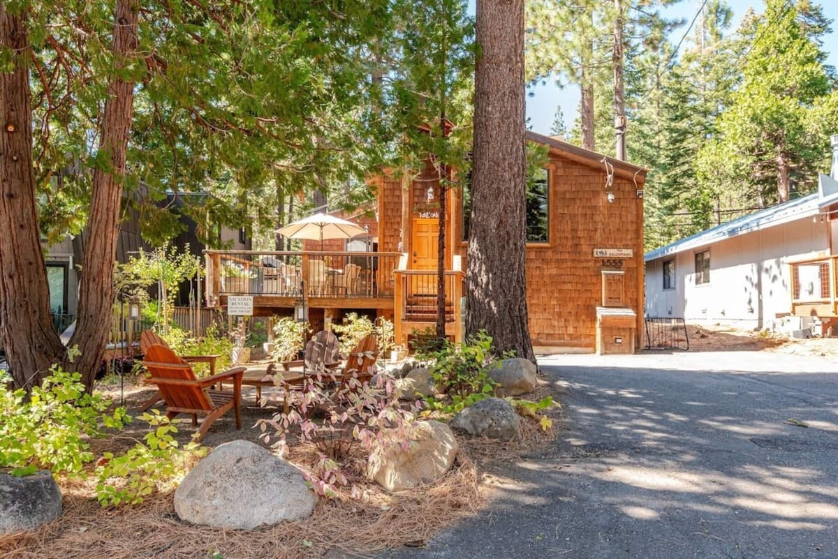 Exterior view with driveway, deck, and outdoor seating area.